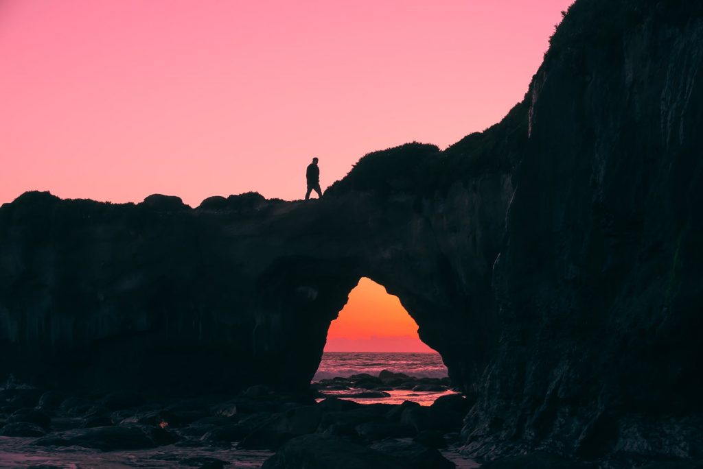 silhouette of man on rock walking during nightime